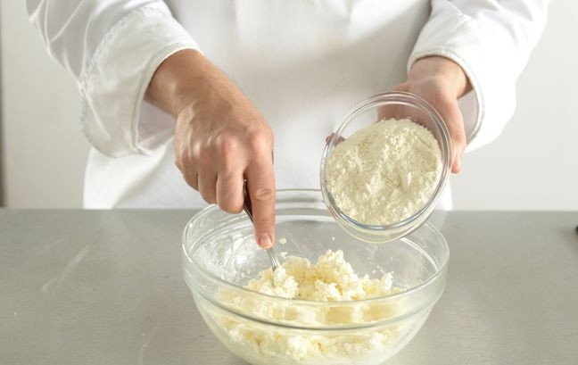 1. Этап. Творожное тесто без дрожжей: Муку просейте и добавьте к ней остальные сыпучие ингредиенты, а именно соль, сахар и соду. Тщательно перемешайте все ингредиенты до полной однородности.