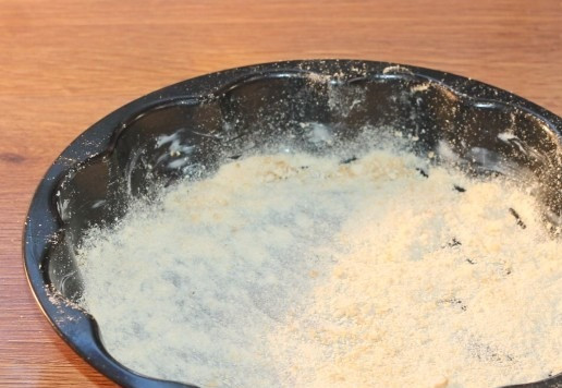 1. Этап. Пирог на кефире с персиками: 12. Смазываем форму (ф=23 см) для выпечки сливочным маслом. И посыпаем измельченным печеньем (2 ст. л.).