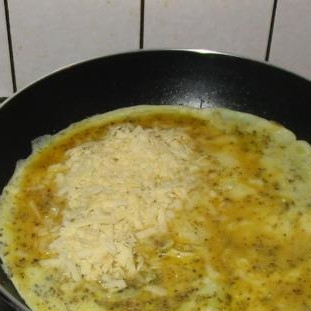 1. Этап. Омлет на завтрак: Разогрейте масло в сковороде. Залейте яичную смесь. Через 30 секунд смешайте еще раз но уже в самой сковороде. Равномерно посыпать тертым сыром.