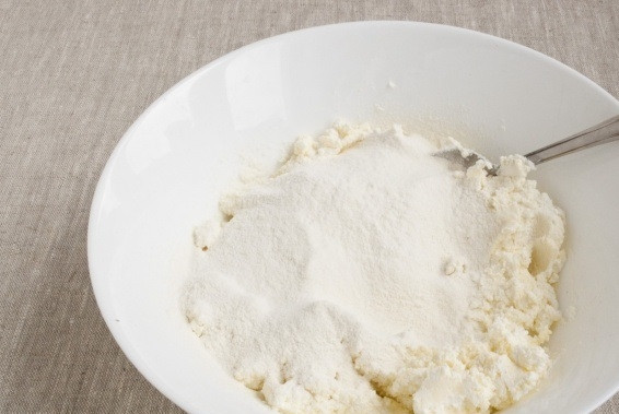 1. Этап. Творожное тесто для рогаликов: 3. Разомните до однородности, добавьте щепотку соли и небольшими порциями всыпайте муку, предварительно просеяв её.