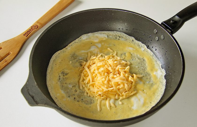 1. Этап. Яичные блины с сыром: Сковороду разогрейте и смажьте маслом. Вылейте яичную смесь и как только блинчик схватится, положите по центру начинку, в данном случае - тертый сыр.