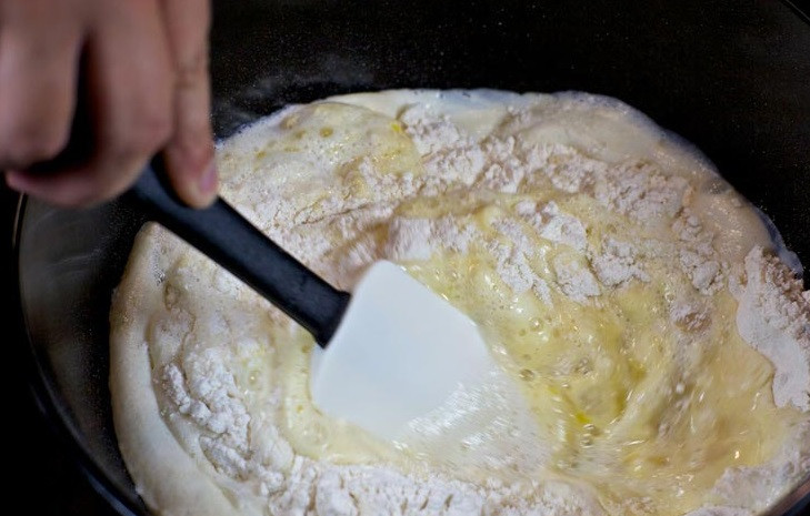 1. Этап. Пирожки, жареные на сковороде: 5. Постепенно всыпать муку, помешивая тесто. Когда тесто начнет загустевать, его можно переместить на стол и тщательно вымесить руками.