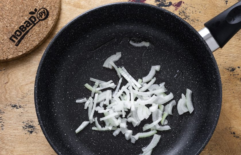 1. Этап. Бурито с кукурузой: Репчатый лук нарежьте тонкими полукольцами. Обжарьте в сковороде до мягкости.