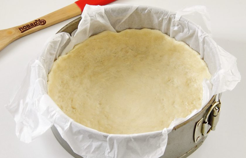 1. Этап. Пирог со сладким перцем и курицей: Форму для выпечки застелите пергаментом и смажьте маслом. Положите в форму тесто и равномерно распределите, формируя высокие бортики.