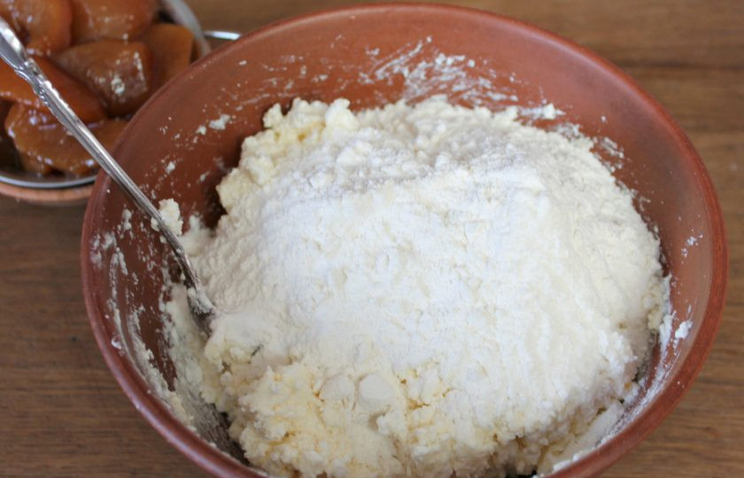 1. Этап. Творожное печенье с фруктами: Добавляем щепотку соды и порциями насыпаем муку. Замешиваем тесто.