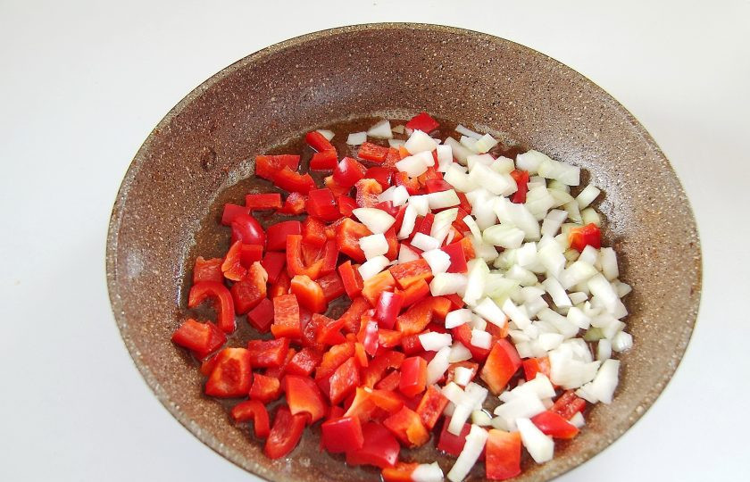 1. Этап. Африканская курица: 4. Курицу уберите на тарелку, а на эту же сковороду выложите нарезанный кубиками лук и болгарский перец. Отложите в сторону.