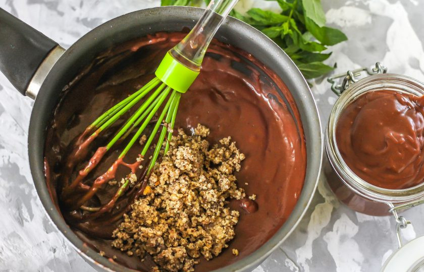 1. Этап. Домашняя паста Нутелла: Часть шоколадной пасты выложите в отдельную емкость, в контейнер или баночку - это домашняя Нутелла без орехов. В оставшуюся массу вмешайте ореховую пасту. Это могут быть измельченные грецкие орехи, фундук, арахис или специальная ореховая арахисовая паста.