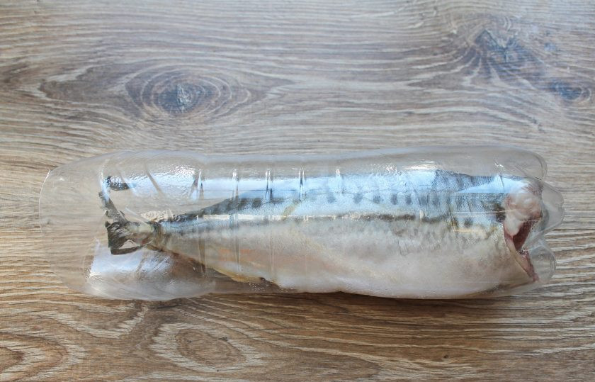 1. Этап. Скумбрия в бутылке как копченая: У полиэтиленовой бутылки обрежьте верх и опустите внутрь скумбрию.