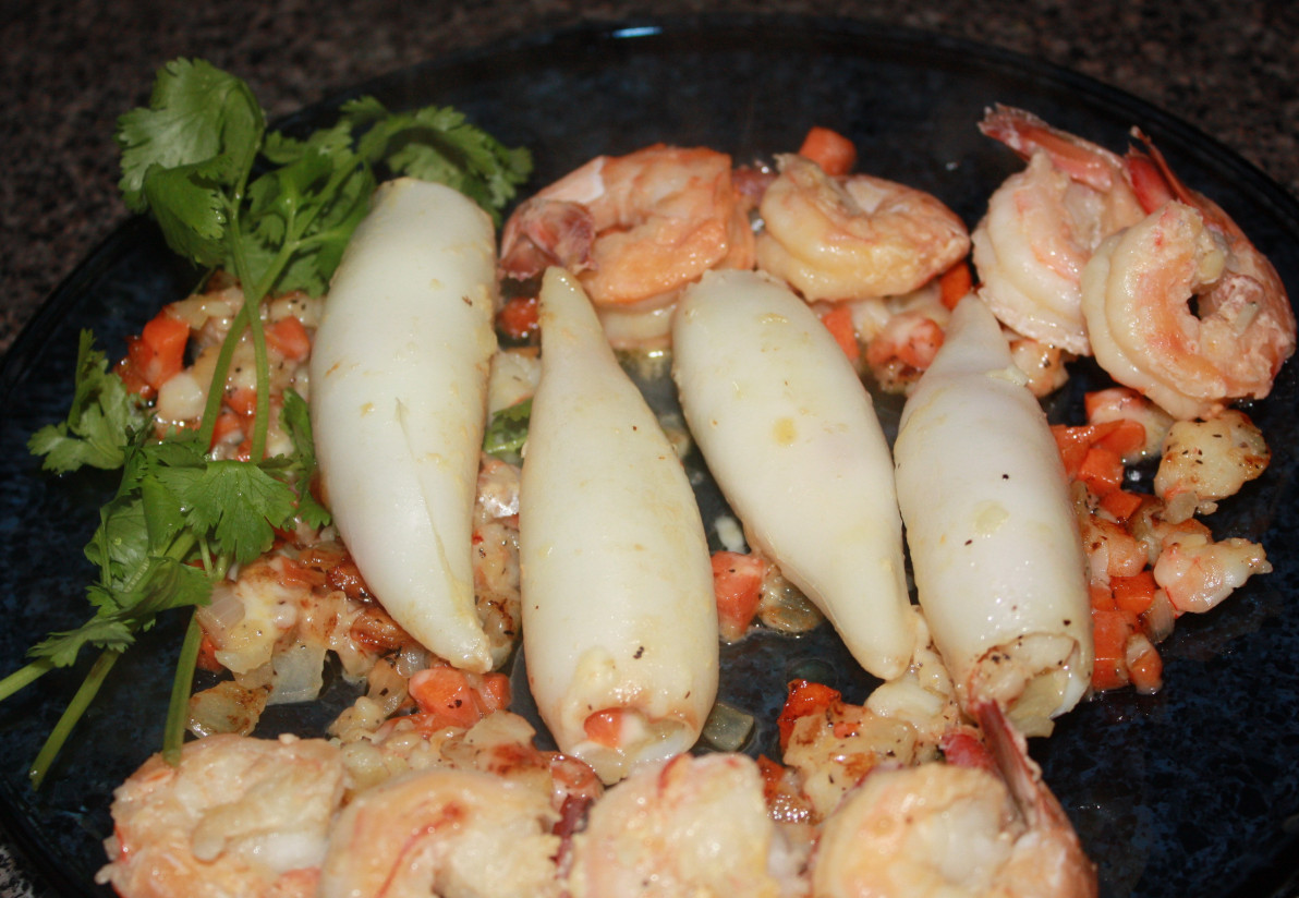 1. Этап. Дары Нептуна (фаршированные кальмары): жарим с каждой стороны по 5 мин, добавляем оставшиеся криветки предварительно посыпав половиной чеснока тушим 2 минуты, снимаем с огня и накрываем крышкой, пока накрываете на стол и разливаете вино. Если у вас остался фарш, то подогрейте его на сковородке, выложите на дно тарелки, а сверху кальмары. Подавать к столу сразу, не оставляйте на завтра, вкус будет уже не тот.