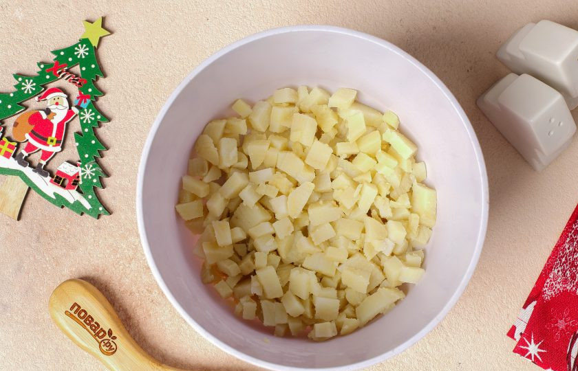 1. Этап. Салат Оливье на год Кролика: Картофель нарежьте кубиками и переложите в глубокую миску.