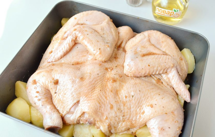 1. Этап. Курица с медом: 4. Курицу можно запечь как целиком, так и частями. У меня духовка маленькая, поэтому я разрезала ее по грудинке и развернула. В таком виде она запечется быстрее. Чтобы сэкономить время на приготовлении ужина я сразу положила дольки картофеля на дно, а сверху разместила курочку.