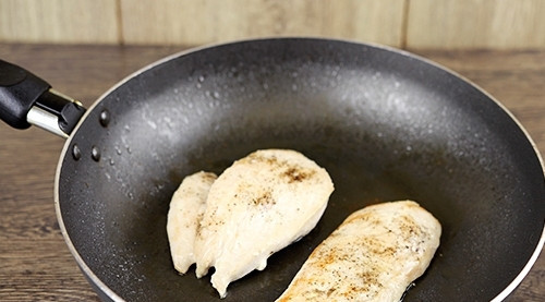 1. Этап. Простой рецепт Цезаря с курицей: Курицу разделите на 2 части. Посолите и поперчите. Обжарьте филе в масле с обеих сторон по 5 минут.