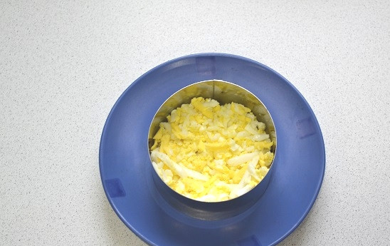 1. Этап. Салат с сыром, яйцом и соленым огурцом: 3. Яйца очистите, натрите на терке и выложите первым слоем. Можно подавать салат вот таким образом, в кольце, или в небольшом глубоком салатнике.