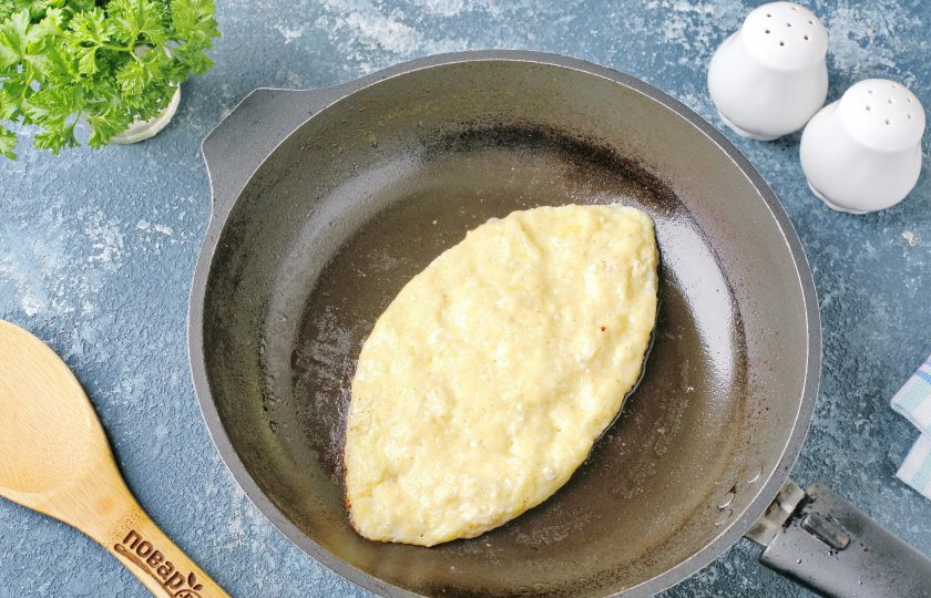 1. Этап. Хачапури из кабачков: Хорошую сковороду с антипригарным покрытием смажьте сливочным или растительным маслом и переложите кабачковую массу. Убавьте огонь до минимального и при помощи двух лопаток придайте заготовке продолговатую форму, напоминающую лодочку. Накройте сковороду крышкой и на минимальном огне готовьте около 5-7 минут (обязательно следите за тем, чтобы низ не подгорел).