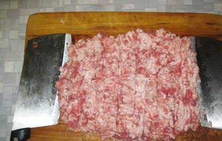 1. Этап. Фарш для пельменей: Продолжаем готовить начинку. Как только говядина была нарублена в фарш, пришла пора свинины. Ее особо обрезать не нужно, поскольку там в основном не пленки, а сало, но, разумеется, если что-то вас во внешнем виде не устраивает - лучше это срезать и отправить в бульон. По моему убеждению, наличие сала в пельменях - вещь очень важная, поскольку именно сало делает начинку блюда мягче, нежнее и сочнее. Итак, рубим свинину в фарш. Если в процессе рубки топориком жирные куски свинины начинают прилипать к топорику, то просто погрейте топорики несколько секунд под струей горячей воды из-под крана.