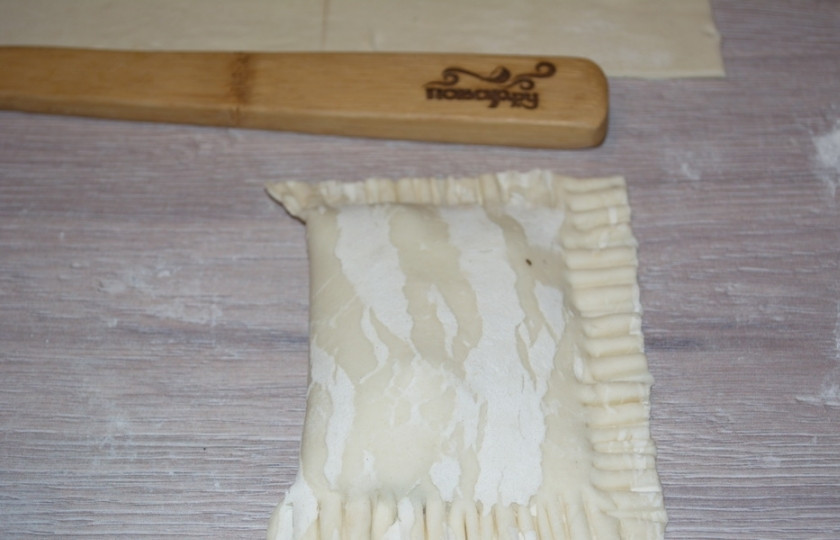 1. Этап. Конвертики из слоеного теста: Накройте начинку второй частью прямоугольника, хорошо закрепите-защипните края. Неровности обрежьте, придайте краю рисунок вилочкой.