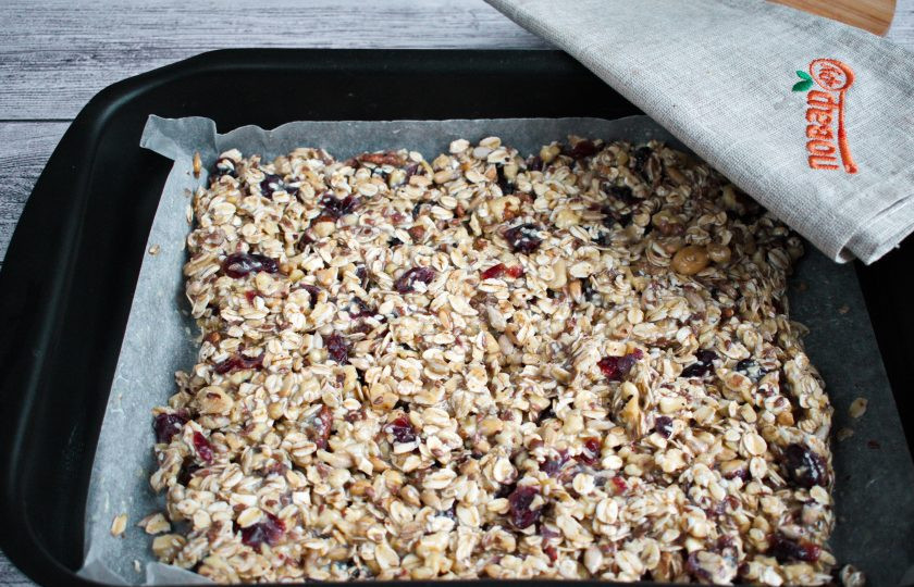 1. Этап. Батончики мюсли с орехами: Орехи измельчите. Смешайте овсяные хлопья, семена, орехи и сухофрукты. Добавьте сгущенку, перемешайте. Форму для запекания (22*30 см) застелите пергаментом для выпечки. Выложите смесь в форму, разровняйте. Не прижимайте сильно.