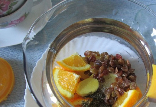 1. Этап. Чай зеленый с ароматными добавками: В чайник бОльшей ёмкости поместить нарезанные кружки лимона и нарезанные на четыре части дольки апельсина. Насыпать предварительно промытый изюм и сушёную мяту. Имбирь очистить, нарезать тонкими пластинами и тоже добавить в чайник.