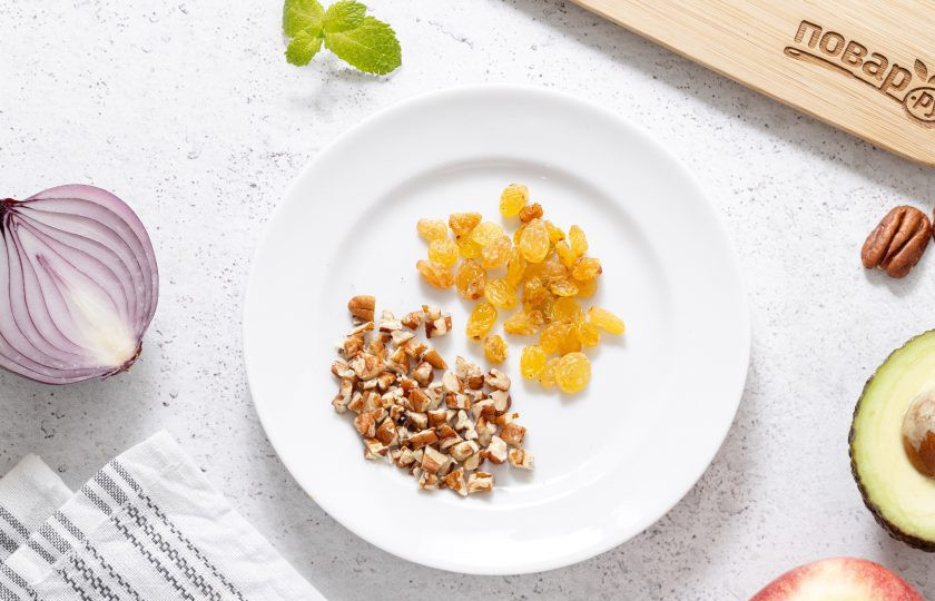 1. Этап. Салат с авокадо и яблоком: Изюм промойте в теплой воде и обсушите с помощью бумажных полотенец. Пекан обжарьте на сухой сковороде до легкого золотистого цвета и измельчите ножом.