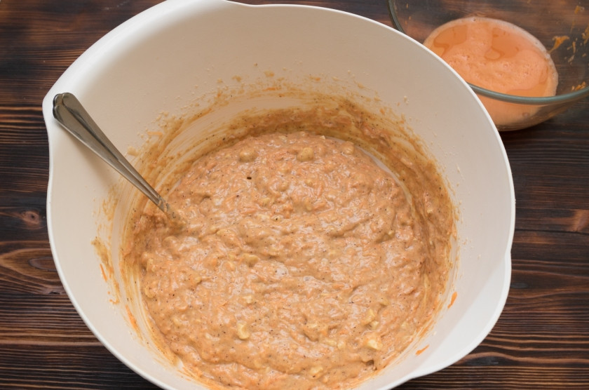 1. Этап. Морковный торт классический: Затем в тесто необходимо ввести морковь. Если она очень сочная, то отожмите лишний сок в миску. Тщательно перемешайте тесто, оно должно быть очень густым. Если влаги все-таки не хватает, то можно добавить пару ложек отжатого морковного сока.