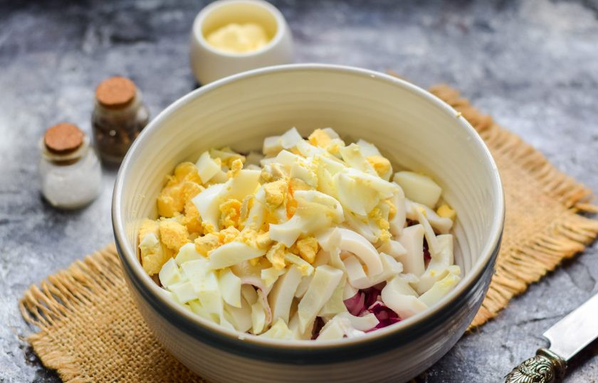 1. Этап. Салат из кальмаров с маринованным луком: Яйцо отварите 10 минут, после очистите и нарежьте кубиками. Добавьте яйца в салат.