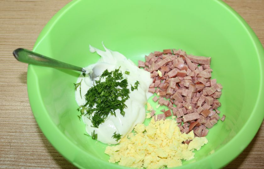 1. Этап. Порционный салат на Новый год: Мелко нарежьте ветчину. Добавьте сыр, желтки яиц, мелко нарезанный укроп.