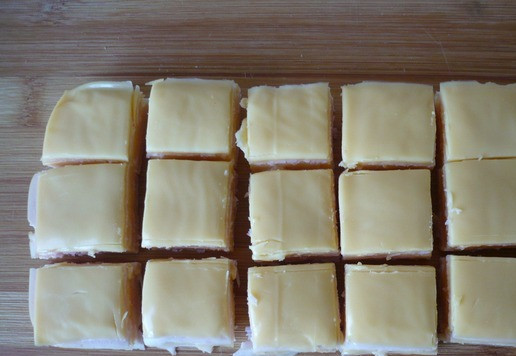 1. Этап. Кубики ветчины и сыра для перекуса: Обрежьте ветчину с сыром так, чтобы получился прямоугольник. Нарежьте его кубиками одинакового размера.