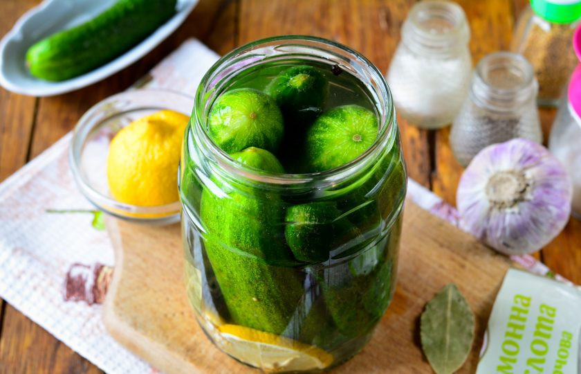 1. Этап. Огурцы с лимоном на зиму: Вскипятите воду и залейте огурцы. Оставьте под крышкой на 10 минут.