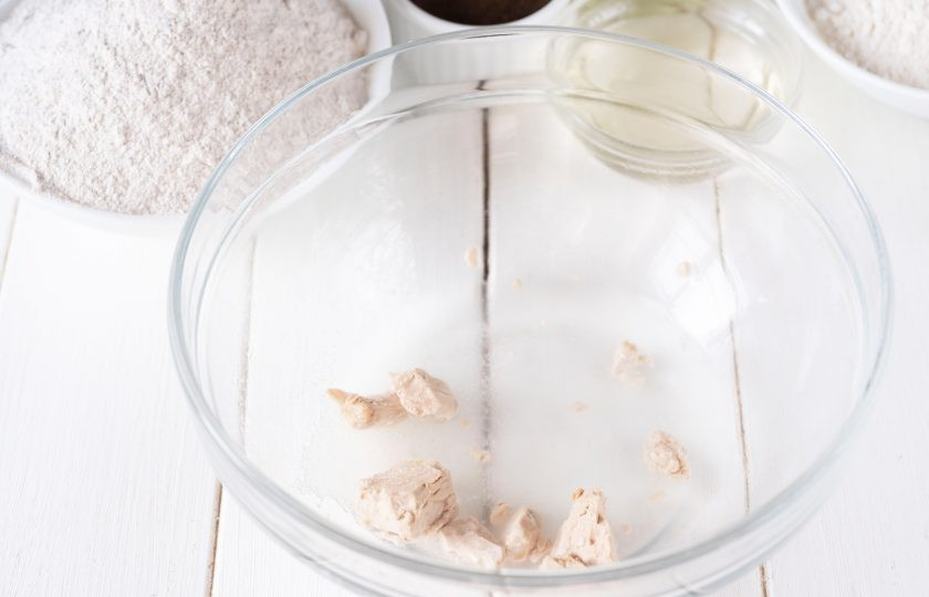 1. Этап. Ржаной хлеб на сыворотке: Разотрите пальцами дрожжи в просторную миску, добавьте сахар, залейте теплую воду.