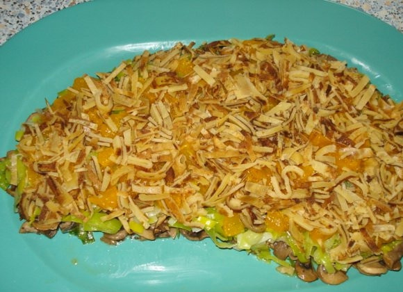 1. Этап. Салат Золотая лошадь: Нарежьте мелко чищенные мандарины. Смешайте с тёртым сыром. Уложите сверху лука-порей.