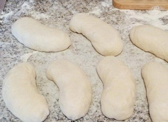 1. Этап. Сардельки в тесте жареные: Спустя это время раскатайте тесто, разрежьте его на кусочки и формы необходимого размера. Сардельки разрежьте продольно и выложите в тестовые лепёшки, тщательно закрепляйте тесто по краям.