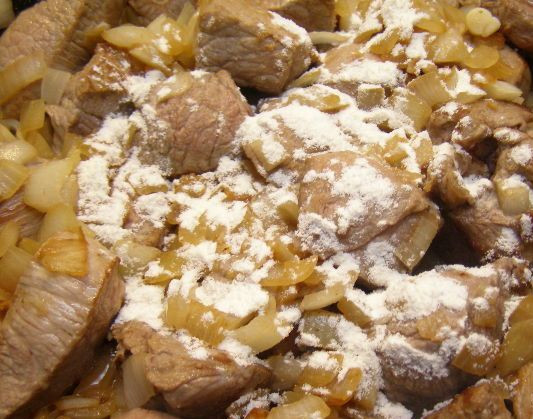 1. Этап. Гуляш из вареной говядины: 3. После того, когда мясо будет готово, нарезаем его кубиками и отправляем на сковороду. Жарим на слабом огне на небольшом количестве растительного масла. В середине жарки добавляем мелко нарезанные лук и морковь, а также — пару щепоток муки.