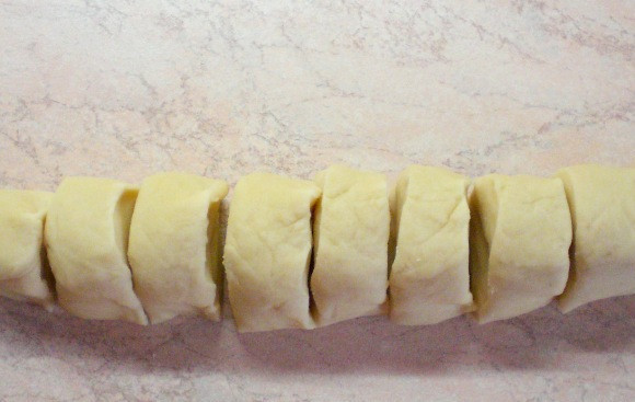 1. Этап. Хинкали с мясом: Подошедшее тесто еще раз обминаем и отрезаем от него кусок. Раскатываем его в колбаску, которую потом нарезаем на небольшие равные части.