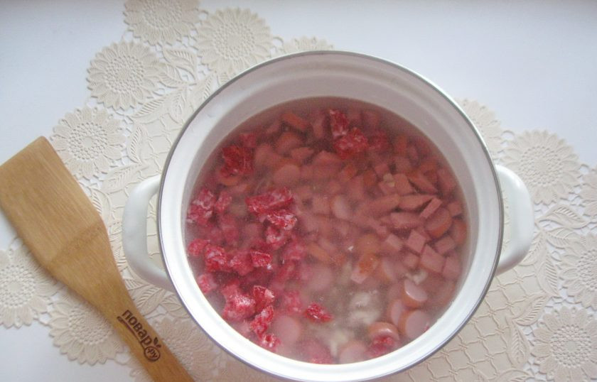 1. Этап. Солянка с лечо: В кастрюлю с куриным бульоном выложите нарезанную колбасу, сосиски и курицу.