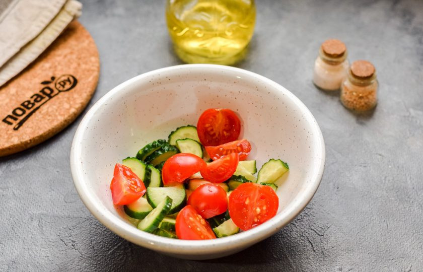 1. Этап. Салат с мидиями: Ополосните и просушите помидоры, огурцы. Нарежьте овощи небольшими кусочками. Переложите помидоры и огурцы в салатник.