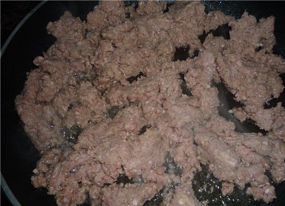 1. Этап. Пирог с мясом из слоеного бездрожжевого теста: Репчатый лук очистим от шелухи и нарежем очень мелко, добавим в фарш и отправим все на сковороду с растительным маслом. Добавим еще соль и перец и обжарим в течении 10 минут.