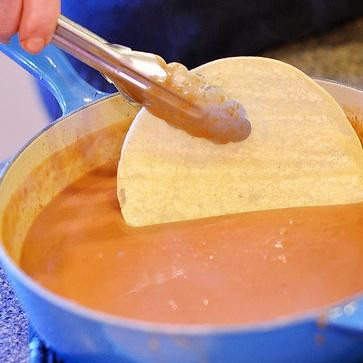 1. Этап. Энфриджоладас: 3. Используя щипцы, взять лепешку и обмакнуть в соус. Лепешки должны размочиться и стать мягкими, не держите их в соусе слишком долго.