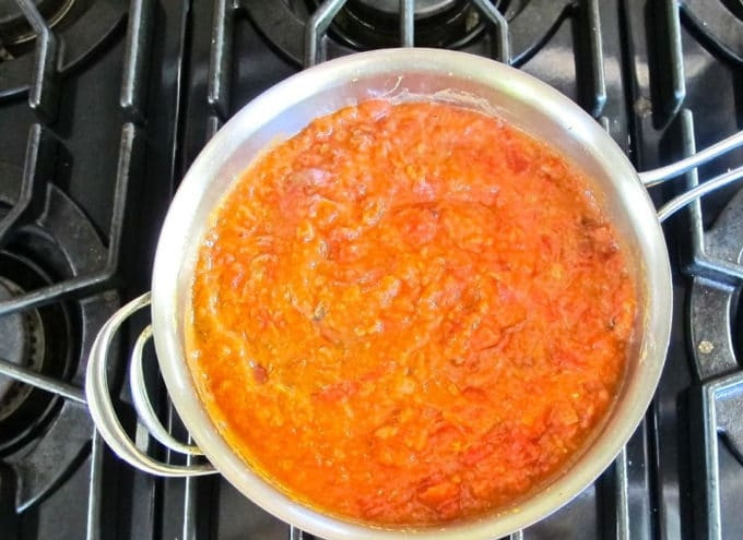 1. Этап. Шакшука с сыром: 2. Следом отправьте на плиту мелко нарезанные помидоры и фасоль (предварительно измельчите её в пюре). Перемешайте ингредиенты.