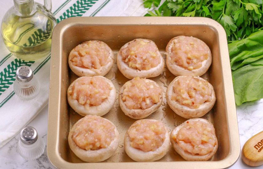 1. Этап. Шампиньоны с куриным фаршем: Аккуратно начините фаршем приготовленные шляпки шампиньонов, выкладывая его с горкой.