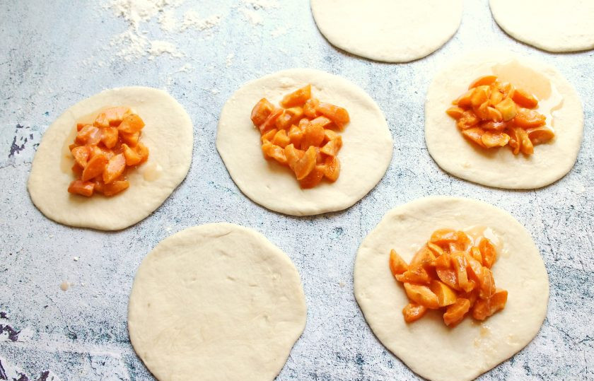 1. Этап. Несдобные пирожки: У абрикосов удалите косточки, порежьте на кусочки и смешайте с крахмалом. Раскатайте шарики в лепешки и выложите в середину начинку, посыпьте сахаром.