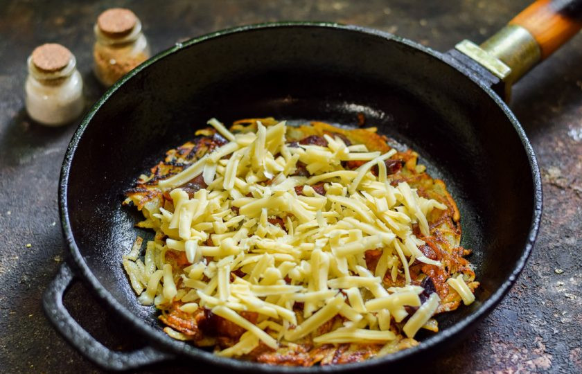 1. Этап. Хашбраун с беконом и сыром: Далее выложите тертый сыр. Готовьте под крышкой 3-4 минуты.