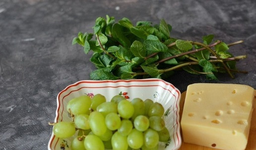 1. Этап. Канапе с сыром, виноградом и мятой: Итак, вот нехитрый набор продуктов для канапе. Для приготовления этих канапе вам потребуется всего три ингредиента. Вместо мяты можете попробовать с листочком свежего зелёного базилика, но мне показалось, что базилик более агрессивен по вкусу, мята нежнее намного. Сыр вы можете брать на свой вкус. Я люблю Маасдам, поэтому взяла именно его. Также и виноград может быть зелёным, красным или чёрным, главное, чтобы он был без косточек. Свежую мяту и виноград вымойте и обсушите на полотенце.