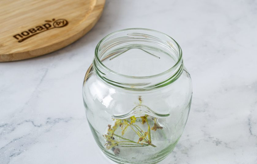 1. Этап. Помидоры без уксуса на зиму: На дно чистой стерилизованной банки выложите перец, гвоздику и зонтик укропа.