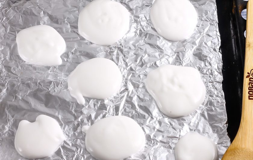 1. Этап. Безе без миксера: Прогрейте духовку до 80 градусов. Застелите фольгой противень и выложите на него столовой ложкой взбитый белковый крем на расстоянии друг от друга. Поместите противень в духовку и высушите безе в течение 1-1,5 часов, приоткрыв дверцу техники.