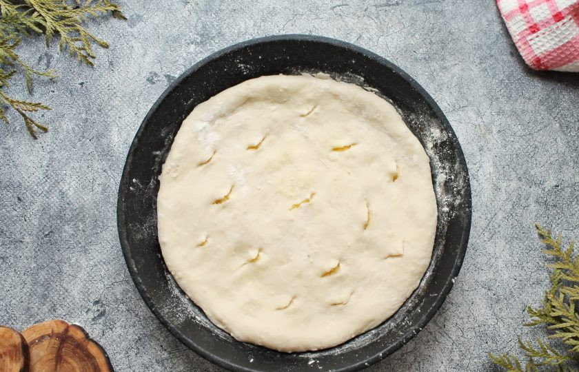 1. Этап. Осетинский пирог с картошкой и сулугуни: Соедините тесто поверх начинки и защипните. Переверните швом вниз и осторожно руками немного прижмите. Сковороду посыпьте мукой, переложите пирог и потихоньку разминайте пирог в лепешку до краев сковороды. Сделайте небольшие дырочки, не проколов до дна или одну в середине.