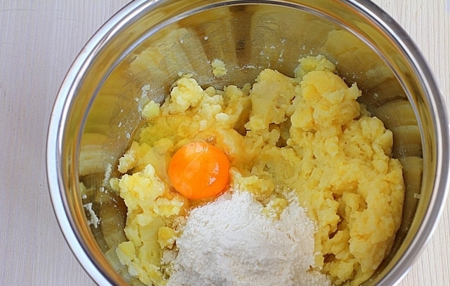 1. Этап. Картофляники с грибами: 1. Первым делом отварите в подсоленной воде картофель. Сделайте пюре, немного остудите его. Вбейте 1 среднее яйцо, добавьте по вкусу соль и перец. Всыпьте муку и крахмал. Все как следует перемешайте до однородности.