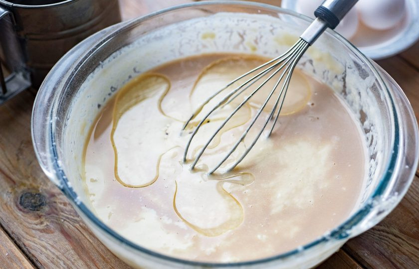 1. Этап. Дрожжевые заварные блины на кефире: В миску залейте дрожжевую смесь и растительное масло. Перемешайте все и залейте тонкой струйкой крутой кипяток, при этом мешать венчиком не прекращайте.