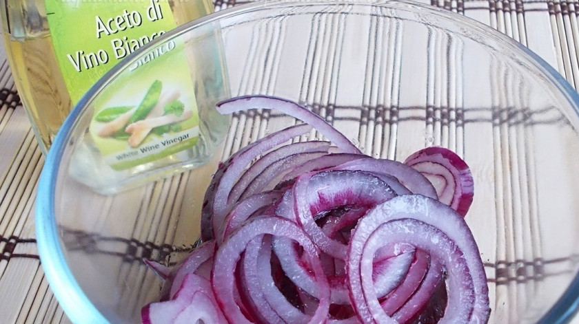 1. Этап. Салат с курицей и киви: Первым делом нарежьте красный лук тонкими кольцами и замаринуйте его в смеси масла, белого винного уксуса, сахара и такого количества соли, которое потребуется вам на весь салат. Слегка помните лук руками и оставьте на несколько минут, пока вы будете готовить остальные продукты для салата с киви и апельсином.