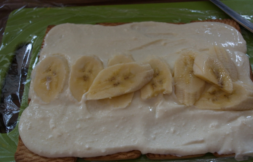 1. Этап. Домик из печенья: Банан нарезать на кусочки произвольной формы. Выложите на центральный ряд печенья.