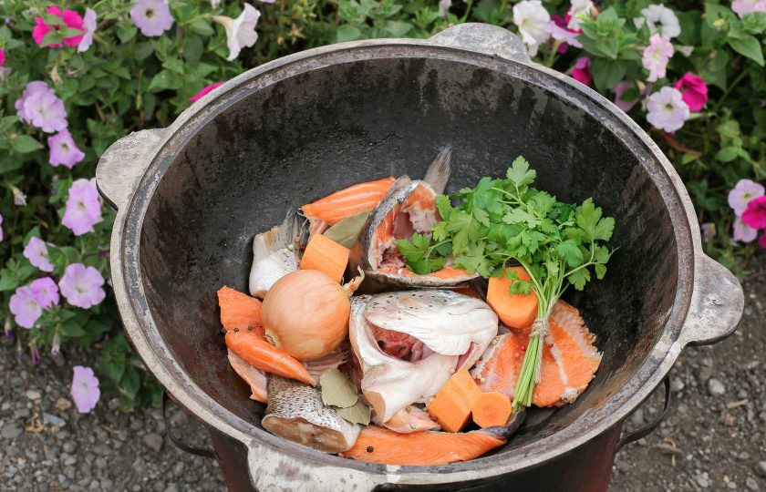 1. Этап. Уха на костре из лосося: Выложите в казан головы, плавниики, хвосты, хребты и поставьте на огонь. Из гoлoв oбязaтeльнo yдaлите жaбpы, a тo yха бyдeт гopчить. Добавьте кнабору для ухи одну луковицу в шелухе, предварительно тщательно её промыв, одну морковь, разрезанную на части, перец горошком, лавровый лист и пучок свежей зелени (у меня петрушка).